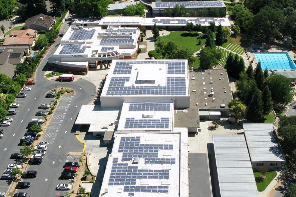 Arial photo showing the solar panels on top of the school buildings.